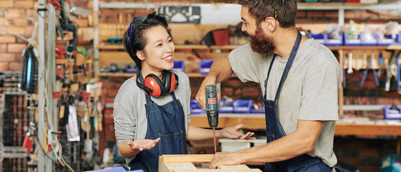 Smiling female carpenter talking to her coworker drilling screws when making wooden drawer Schlagwort(e): Men, Working, People, Occupation, Workshop, Create, Industry, Carpenter, Manual Worker, Male, Female, Box, Standing, Smiling, Skill, Teamwork, Young Adult, Small Business, Caucasian Ethnicity, Wireless Building - Activity, Manufacturing, Carpentry, Craftsperson, Expertise, onstruction Worker, Young Men, Craft, Happiness, Place of Work, Confidence, Equipment, Wood - Material, Work Tool, Coworker, Professional Occupation, Women, Factory, Creativity, Designl, woman, woodwork, job, assembling, drawer, stand, apprentice, helping, positive, Asian, Vietnamese, men, working, people, occupation, workshop, create, industry, carpenter, manual worker, male, female, box, standing, smiling, skill, teamwork, young adult, small business, caucasian ethnicity, wireless building - activity, manufacturing, carpentry, craftsperson, expertise, onstruction worker, young men, craft, happiness, place of work, confidence, equipment, wood - material, work tool, coworker, professional occupation, women, factory, creativity, designl, woman, woodwork, job, assembling, drawer, stand, apprentice, helping, positive, asian, vietnamese