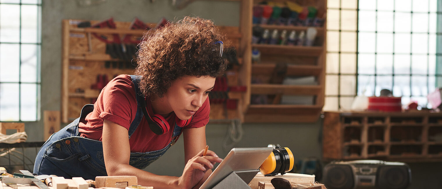 Young concentrated woman with curly hair reading instructions on digital tablet before working with wood Schlagwort(e): woman, female, young, attractive, curly, concentrated, digital, tablet, technology, internet, leaning, table, looking, reading, wifi, carpentry, joinery, timber, wood, wooden, plank, tool, skill, manual, equipment, professional, craft, craftsman, handyman, occupation, working, woodworking, workshop, woman, female, young, attractive, curly, concentrated, digital, tablet, technology, internet, leaning, table, looking, reading, wifi, carpentry, joinery, timber, wood, wooden, plank, tool, skill, manual, equipment, professional, craft, craftsman, handyman, occupation, working, woodworking, workshop