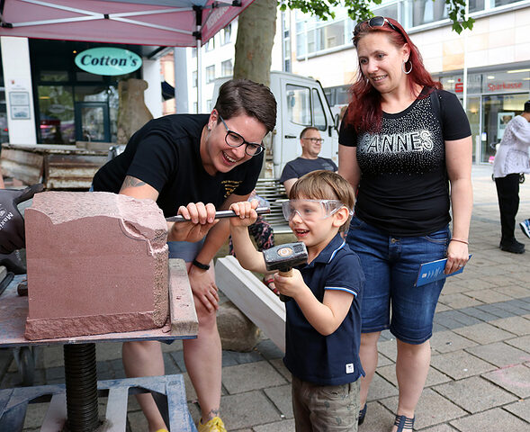 Steinmetzmeisterin Valerie Benz aus Ludwigshafen (l.) zeigte den Kindern, wie sie einen Steinblock mit Werkzeugen bearbeiten können. Steinmetzmeisterin Valerie Benz aus Ludwigshafen (l.) zeigte den Kindern, wie sie einen Steinblock mit Werkzeugen bearbeiten können.