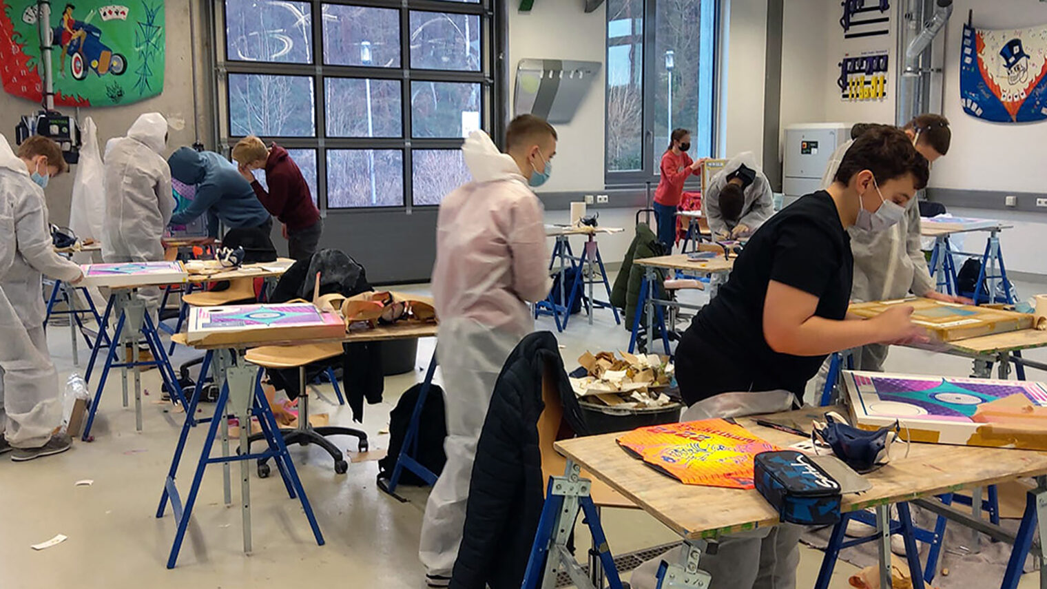 Eine Schülergruppe zu Besuch in der Lackiererwerkstatt des Berufsbildungs- und Technologiezentrums in Kaiserslautern: Selbst ausprobieren und Spaß am Handwerk finden ist angesagt.