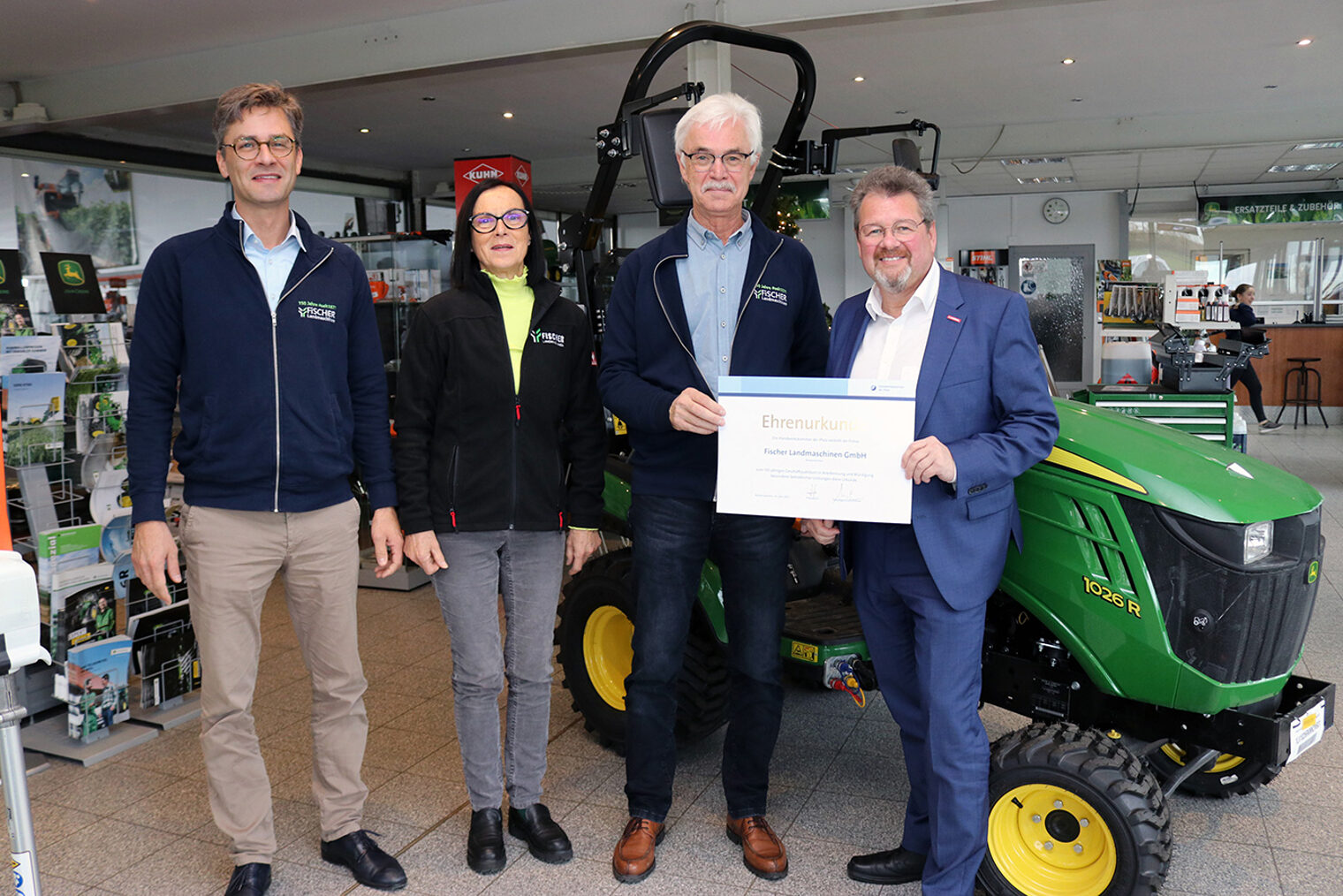 Kammerpräsident Dirk Fischer (r.) überreicht Seniorchef Thomas Fischer die Ehrenurkunde zum Jubiläum. Links: Johannes und Ulrike Fischer