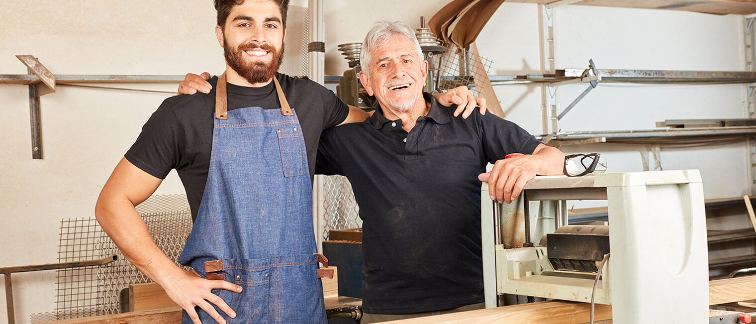 Stolzes Schreiner Team mit Meister und Lehrling arbeitet an der Hobelmaschine Schlagwort(e): Handwerker, Team, Zusammenarbeit, Hobelmaschine, Ausbildung, Azubi, Tischler, Schreiner, Freude, glücklich, stolz, erfolgreich, Teamwork, Meister, Lehrling, hobeln, Maschine, Holzverarbeitung, Balken, Holzbau, Werkstatt, Holz, Mann, Senior, Handwerk, Holzarbeit, Tischlerei, Schreinerei, Arbeiter, arbeiten, lächeln, Zimmermann, Bau, Zimmerei, Arbeit, Beruf, männlich, Holzarbeiter, Industrie, Leute