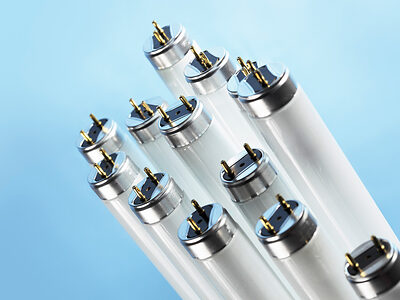 New fluorescent light tubes on blue background Schlagwort(e): fluorescent, light, lighting, tube, tubes, lamp, lamps, T8, T-8, pin, pins, component, electric, electrical, electrics, nobody, objects, object