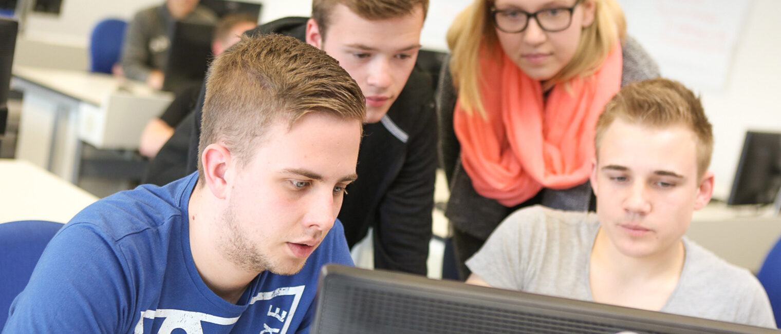 Teilnehmende eines Seminares schauen auf einen Computer Auszubildende nehmen an einem Seminar teil während sie vor Computern sitzen